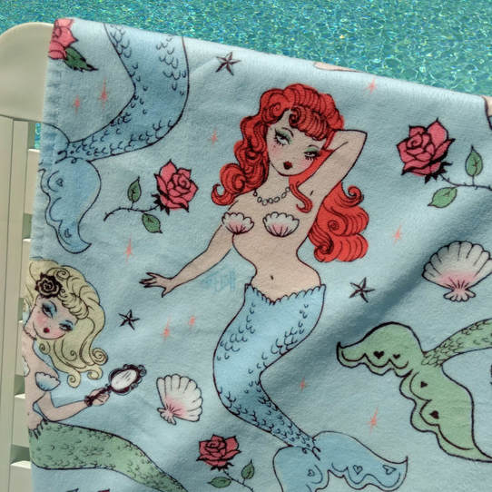Cute beach towel featuring vintage inspired mermaids in beautiful pastel colors by Miss Fluff.